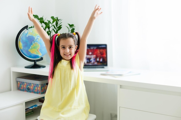 Fantastica scuola online. Bambino che studia online a casa usando un laptop. Allegra giovane bambina che utilizza il computer portatile che studia tramite il sistema di e-learning online. Formazione a distanza o a distanza