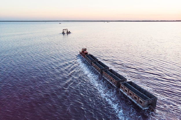 Fantastici viaggi in treno su rotaia nell'acqua con sale bianco sullo sfondo di una bellissima vista aerea del cielo blu vista dall'alto