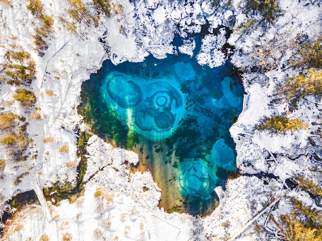 Fantastico lago geyser blu nella foresta autunnale. Altai, Russia vista dall'alto, vista aerea,