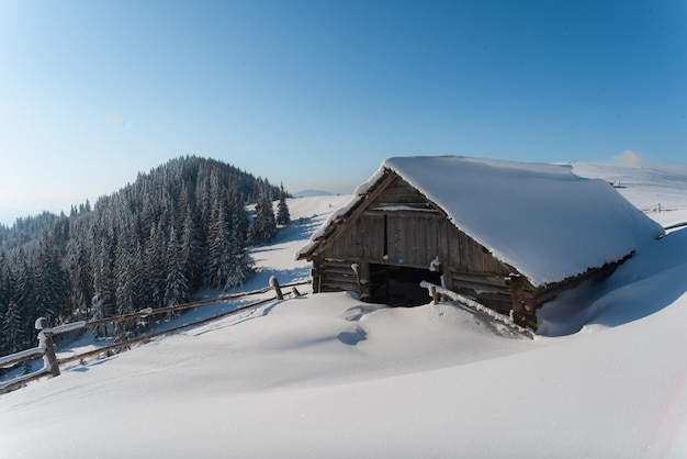 Fantastico paesaggio invernale con casa in legno in montagne innevate. Concetto di vacanza di Natale. Montagna dei Carpazi, Ucraina, Europa