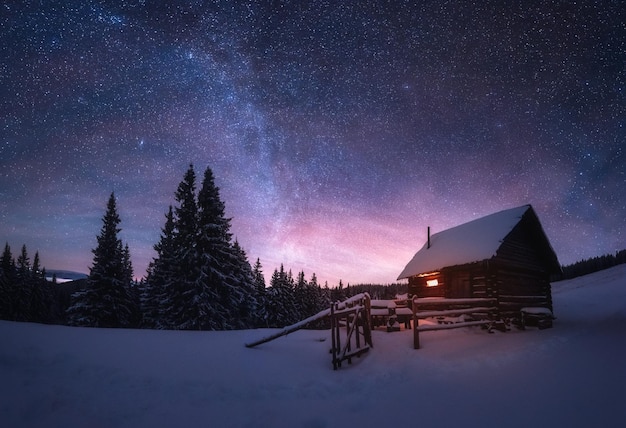 Fantastico paesaggio invernale con casa in legno in montagne innevate