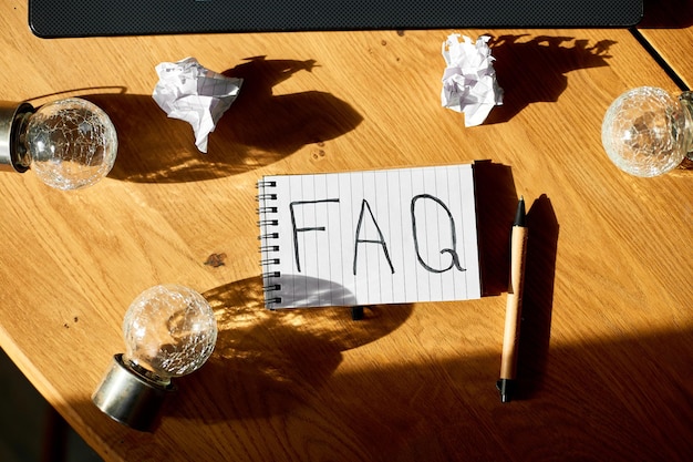 Faq domande frequenti testo su notebook xAon sfondo in legno Concetto di comunicazione aziendale online sociale