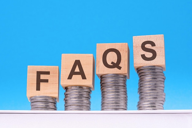 Faq testo su blocchi di legno pila con monete sfondo blu business concetto domande frequenti Domande frequenti