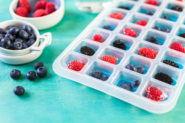 Fare cubetti di ghiaccio di frutta fresca per bevanda estiva.