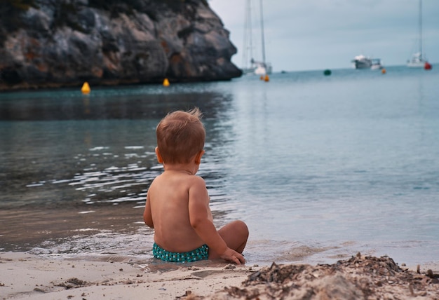 Fare da baby-sitter sulla spiaggia di sabbia in estate