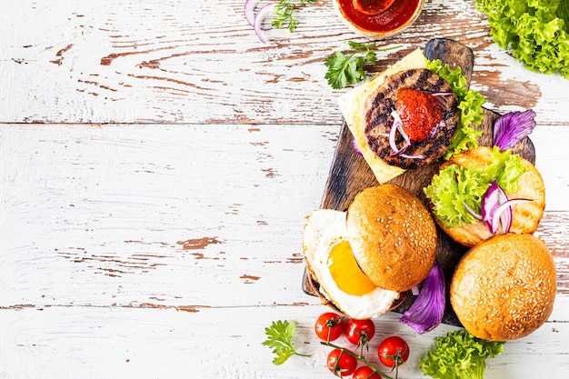 Fare hamburger fatti in casa. Ingredienti per cucinare su un tavolo di legno. Vista dall'alto o distesi. Copia spazio