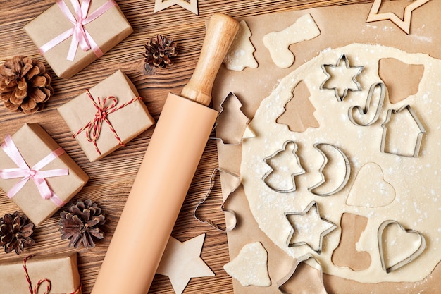 Fare i biscotti di Natale del pan di zenzero Usando il modulo per cucinare su fondo di legno