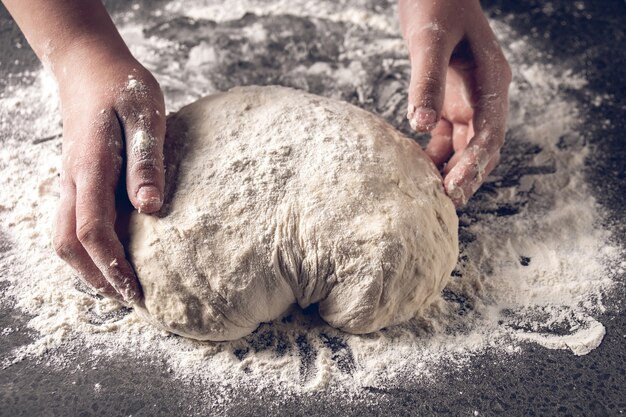 Fare la pasta da mani femminili al forno, produzione di prodotti di farina