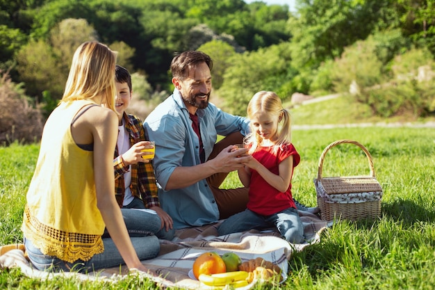 Fare picnic. Felice famiglia amorevole trascorrere del tempo insieme e fare picnic