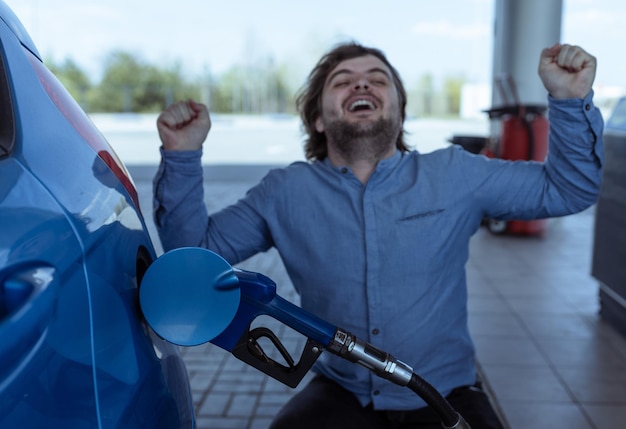 Fare rifornimento di benzina a una stazione di servizio Aumento dei prezzi del carburante Crisi e mancanza di benzina Un uomo urla di rabbia vicino alla stazione di servizio