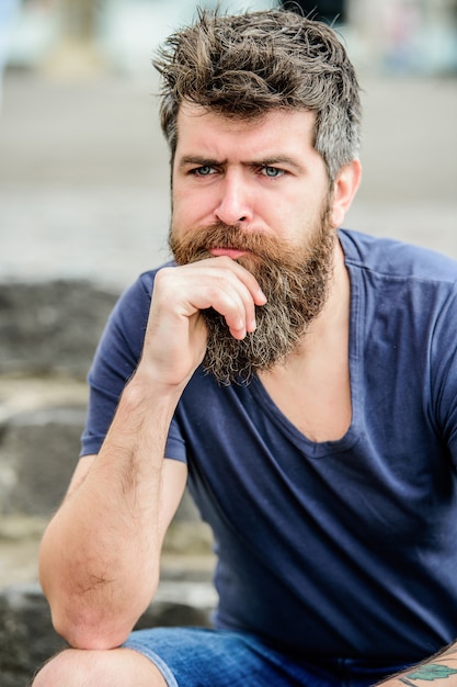 Fare scelte importanti. Uomo con barba e baffi pensieroso turbato. Hipster con l'espressione premurosa della barba. Pensare ed esitare. Fronte concentrato dell'uomo barbuto. Concetto di umore premuroso.