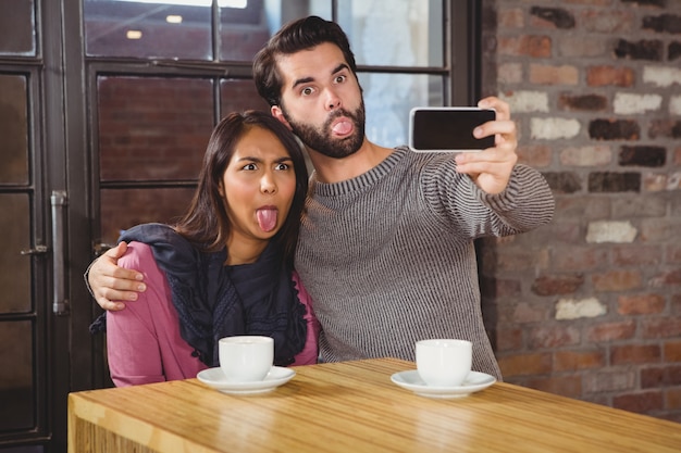 Fare smorfie amici prendendo selfie