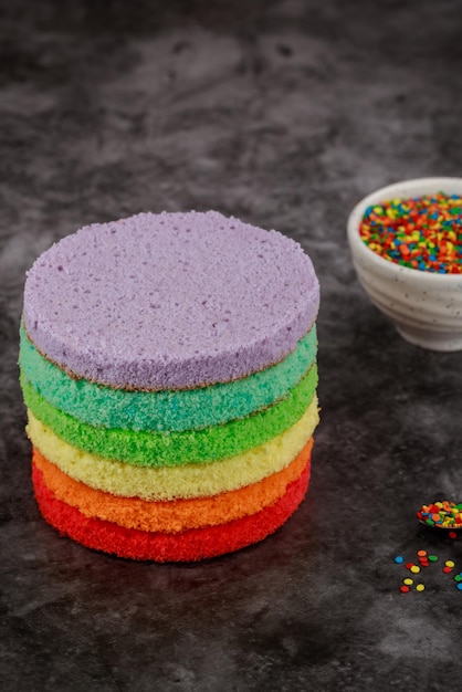 Fare una torta di compleanno arcobaleno colorato con granelli di zucchero.