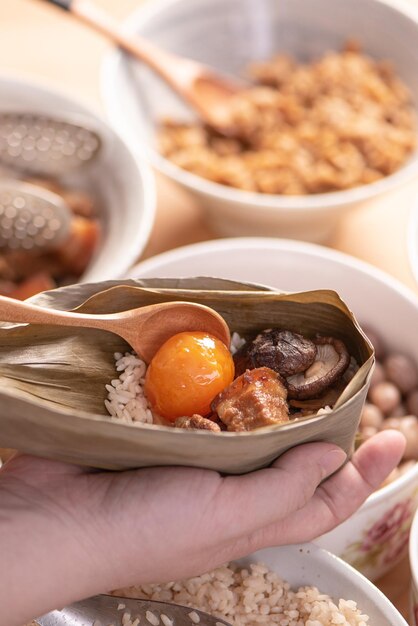 Fare zongzi preparando e avvolgendo gnocchi di riso cinesi