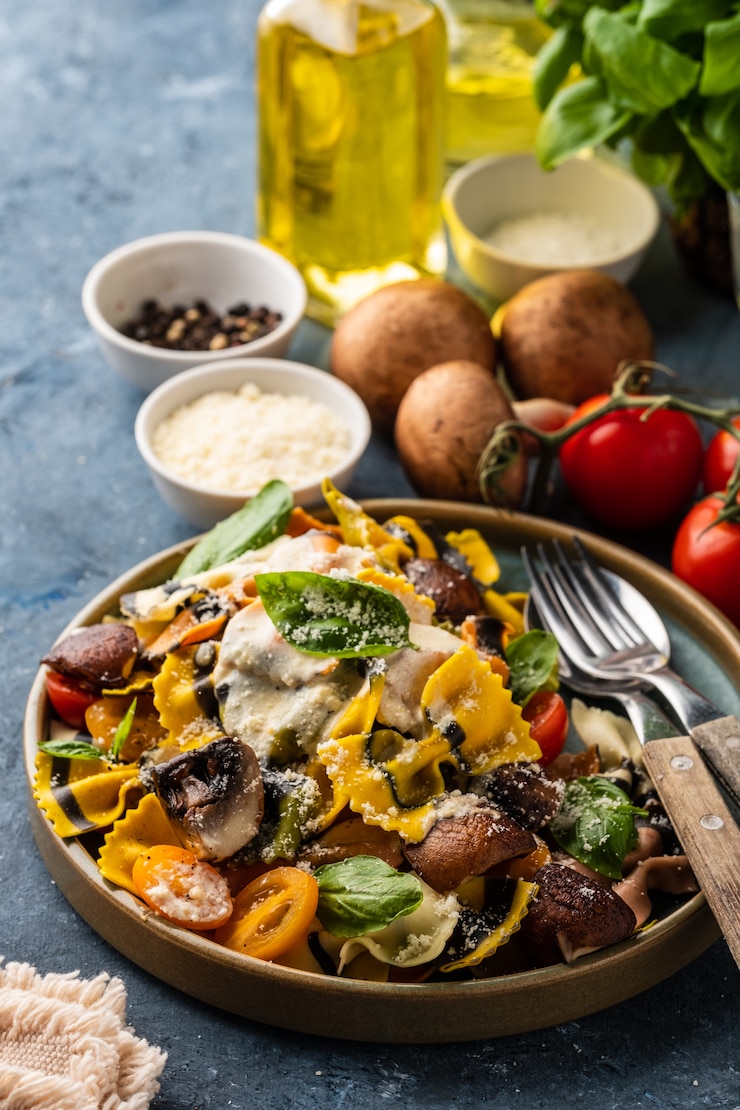 Foto farfalle di pasta con funghi, basilico, pomodori e salsa di panna. cucina tradizionale italiana. cibo mediterraneo