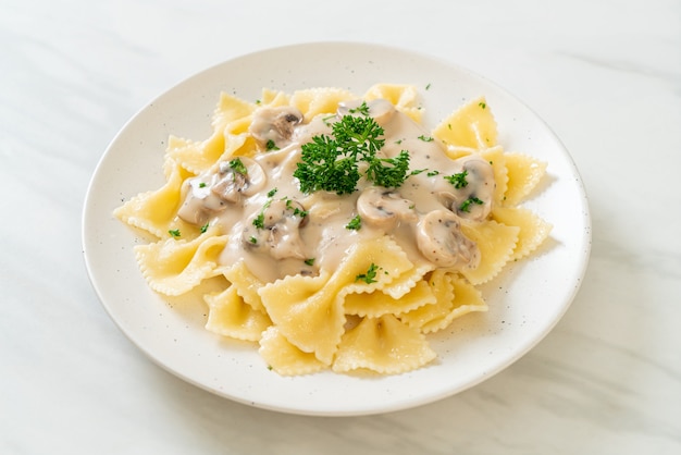 farfalle di pasta con salsa di panna bianca ai funghi - stile alimentare italiano