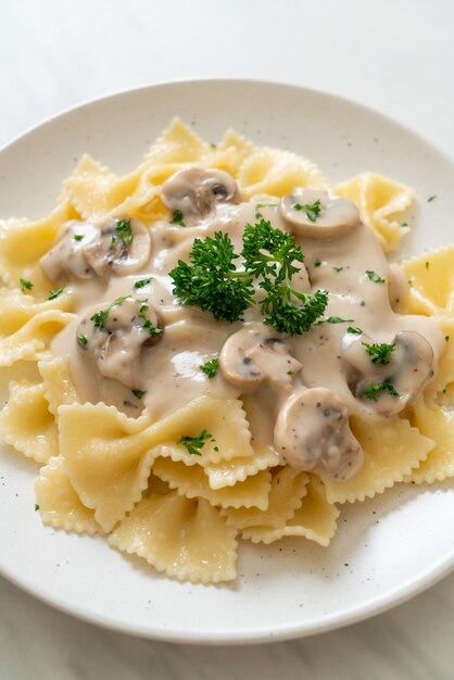 farfalle di pasta con salsa di panna bianca ai funghi - stile alimentare italiano