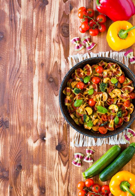 Farfalle di pasta italiana in salsa di pomodoro e vari tipi di verdure