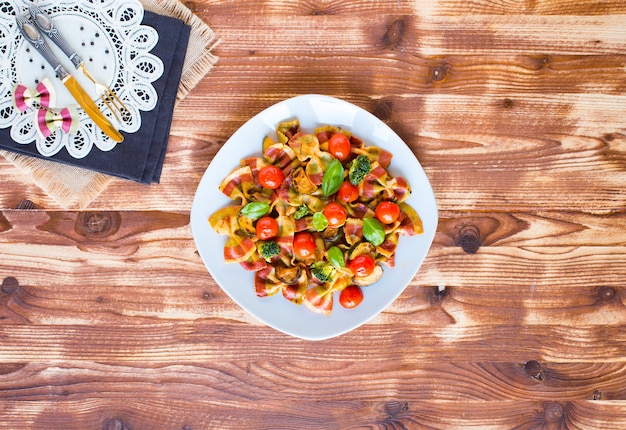 Farfalle di pasta italiana in salsa di pomodoro e vari tipi di verdure