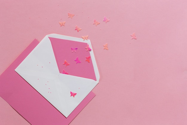 Farfalle rosa nella busta rosa sulla carta rosa