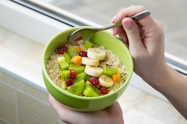 Farina d'avena con frutta fresca in un piatto verde