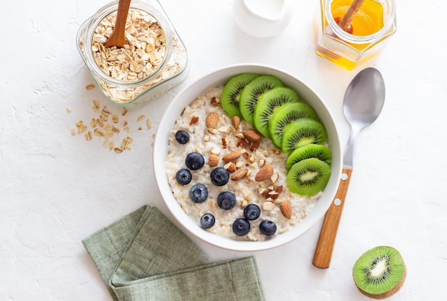 Farina d'avena con kiwi mirtilli mandorle e miele Cibo sano Cibo vegetariano Colazione