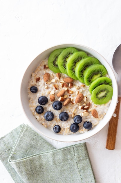 Farina d'avena con kiwi mirtilli mandorle e miele Cibo sano Cibo vegetariano Colazione