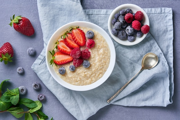 Farina d&#39;avena con mirtillo, fragola, lampone su blu scuro