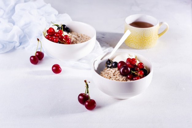 Farina d'avena cruda con yogurt e frutti di bosco di ciliegia, ribes e mirtillo