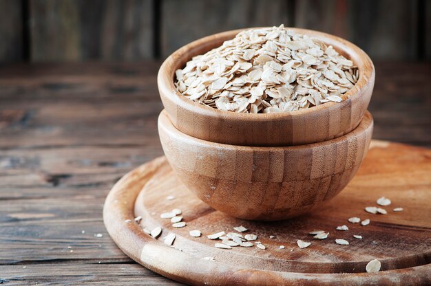 Farina d'avena cruda sulla tavola di legno, fuoco selettivo