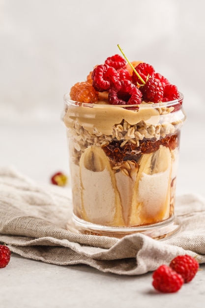 Farina d&#39;avena durante la notte con frutti di bosco, burro di arachidi, banana e frutti di bosco.