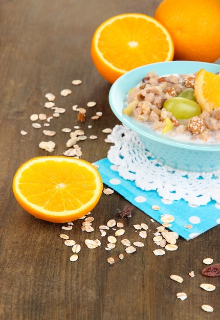 Farina d'avena utile in una ciotola con frutta sul primo piano della tavola di legno