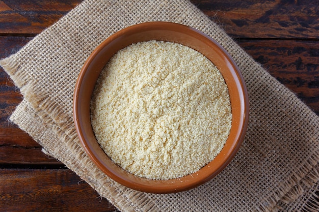 Farina di briciole di pane tostato e schiacciato in una ciotola di ceramica su un tavolo di legno rustico Farina per impanare la carne Vista dall'alto