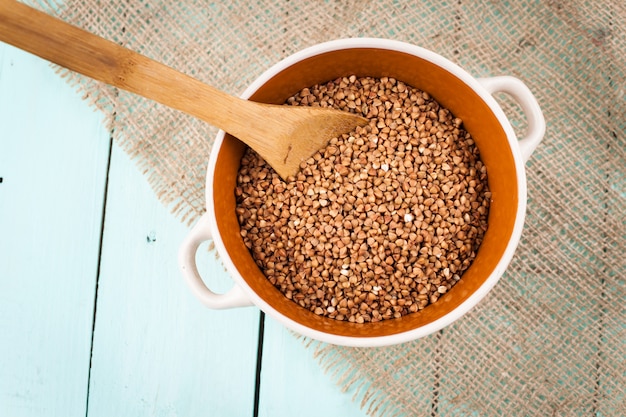 Farina di grano saraceno in una ciotola e cucchiaio di legno