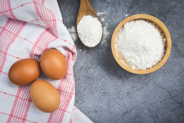 Farina di pasticceria sulla ciotola di legno su fondo grigio