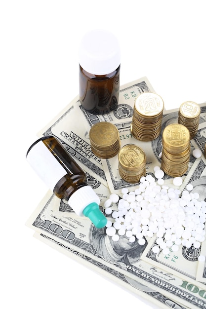 Farmaci da prescrizione su sfondo di denaro che rappresentano l'aumento dei costi sanitari isolati su bianco