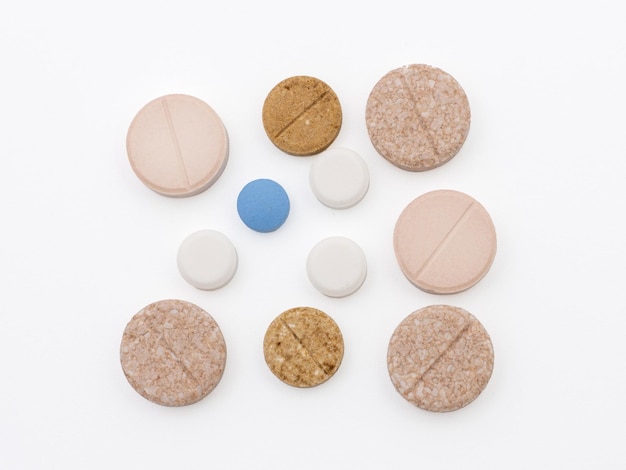 Farmaci in pillole colorate. Piatto isolato giaceva su sfondo bianco.
