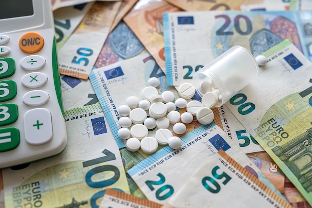 Farmacia ad alto costo concetto pillole denaro e calcolatrice finanza