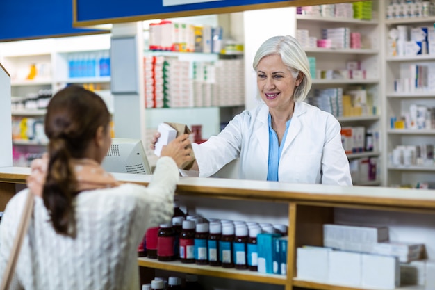 Farmacista che dà la scatola della medicina al cliente