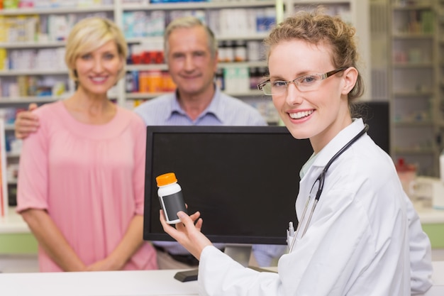 Farmacista che mostra il vaso della medicina ad un cliente