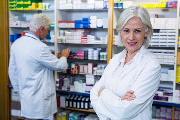 Farmacista che sta con le armi attraversate e collega che controlla le medicine