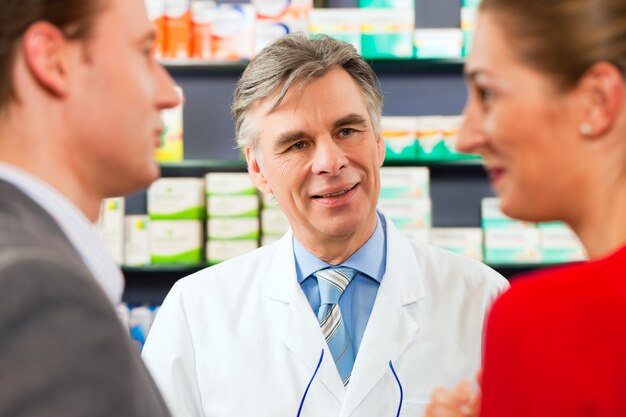 Farmacista con clienti in farmacia