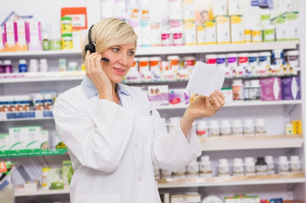 Farmacista con cuffia che legge una prescrizione