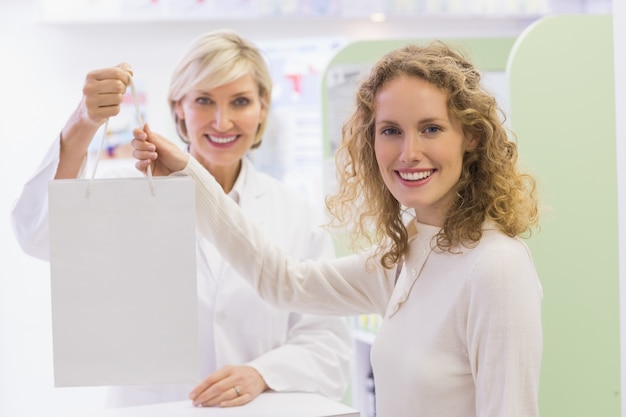 Farmacista e cliente che tiene il sacco di carta