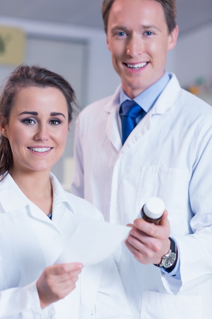 Farmacista e il suo tirocinante guardando la telecamera