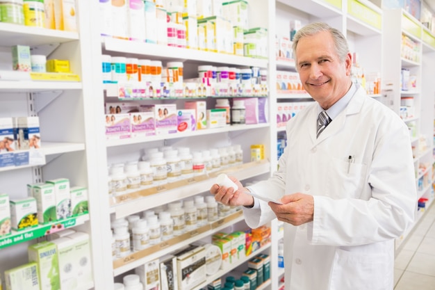 Farmacista e prescrizione senior sorridenti della tenuta del farmacista