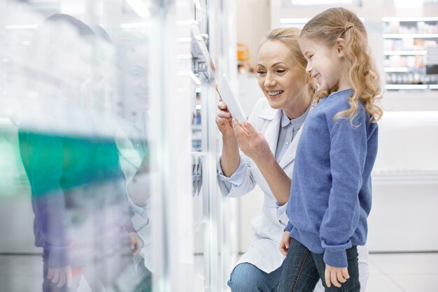 Farmacista femminile che aiuta una bambina in una farmacia