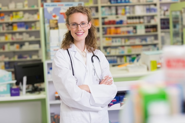 Farmacista in camice da laboratorio con stetoscopio e braccia incrociate