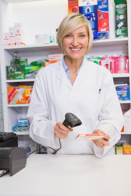 Farmacista sorridente che esamina scatola di medicina