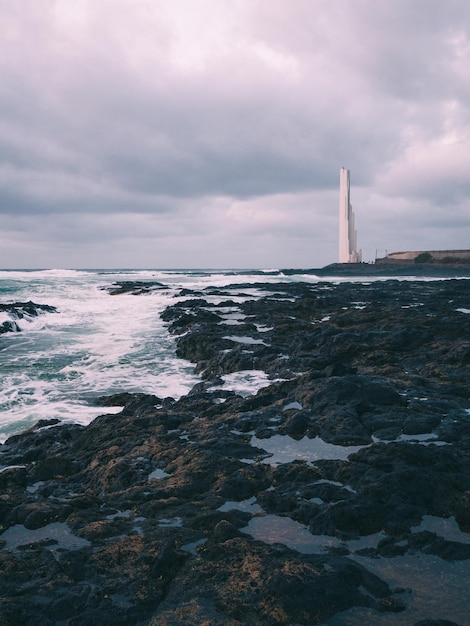 Faro dal mare contro il cielo